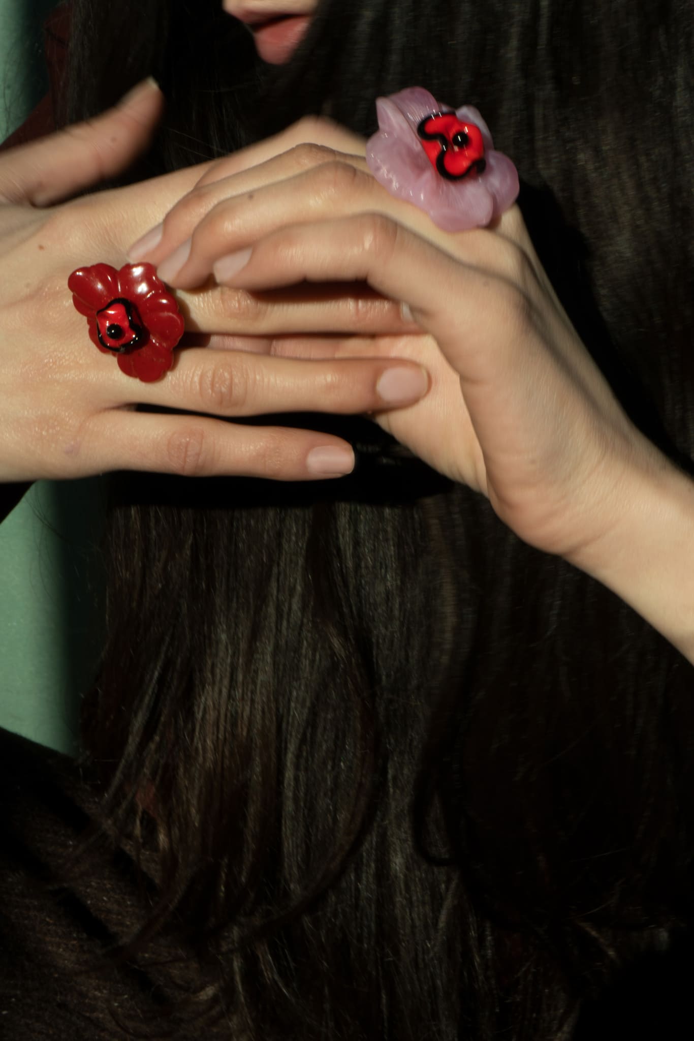 Anillo bordado rouge con diseño floral, flor de vidrio checo y flor de resina vintage, en mano de modelo, marca Uchaworld.