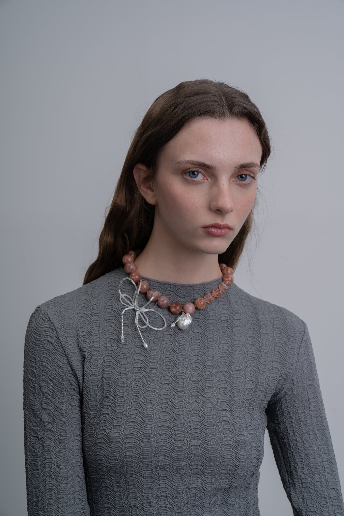 Collar elaborado con plata de ley, piedras naturales y perlas de río, que puede usarse con o sin el moño, en modelo, marca Uchaworld.