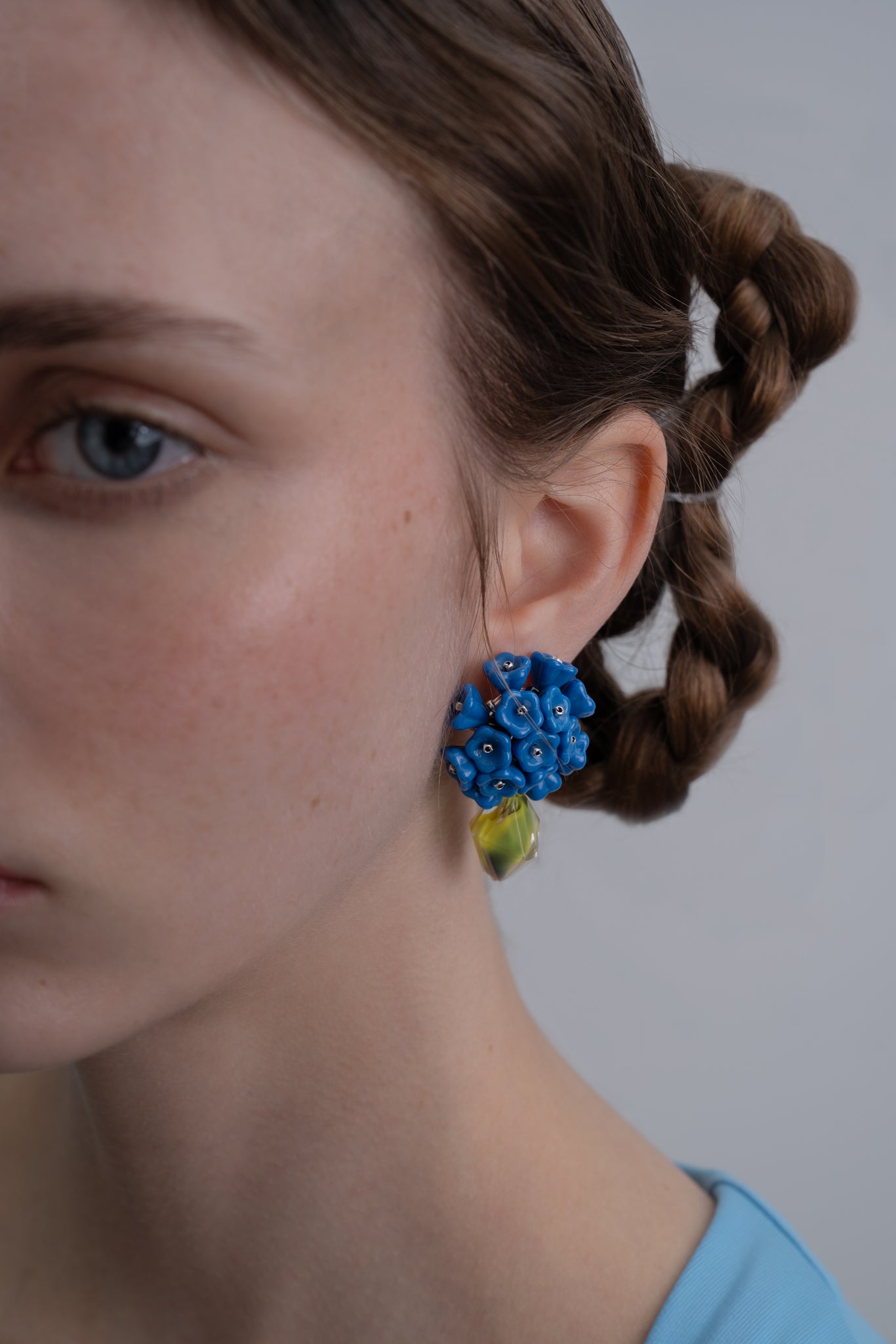 Pendientes bordados en color azul con flores de cristal de checo y cuenta de cristal vintage verde, en modelo, marca Uchaworld.
