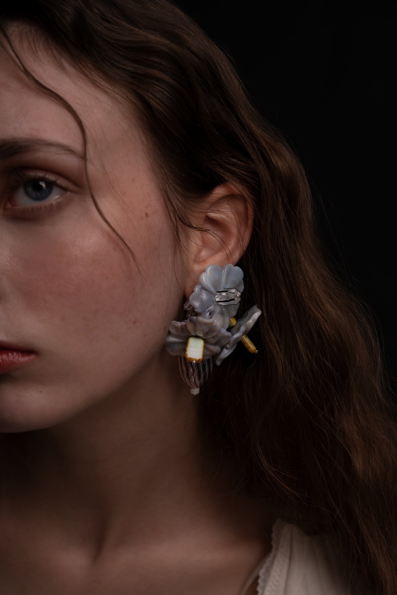 Pendientes bordados en color gris con flores de cristal checo, en modelo, marca Uchaworld.