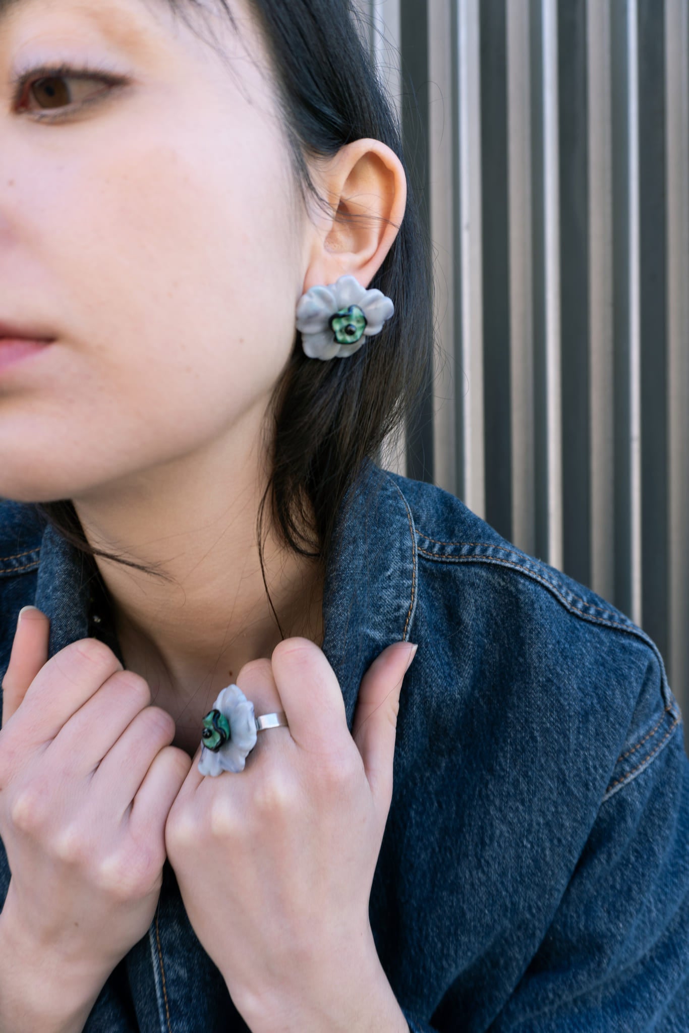 Pendientes bordados gris con diseño floral, flores de vidrio checo y flores de resina vintage, en modelo frente, marca Uchaworld.