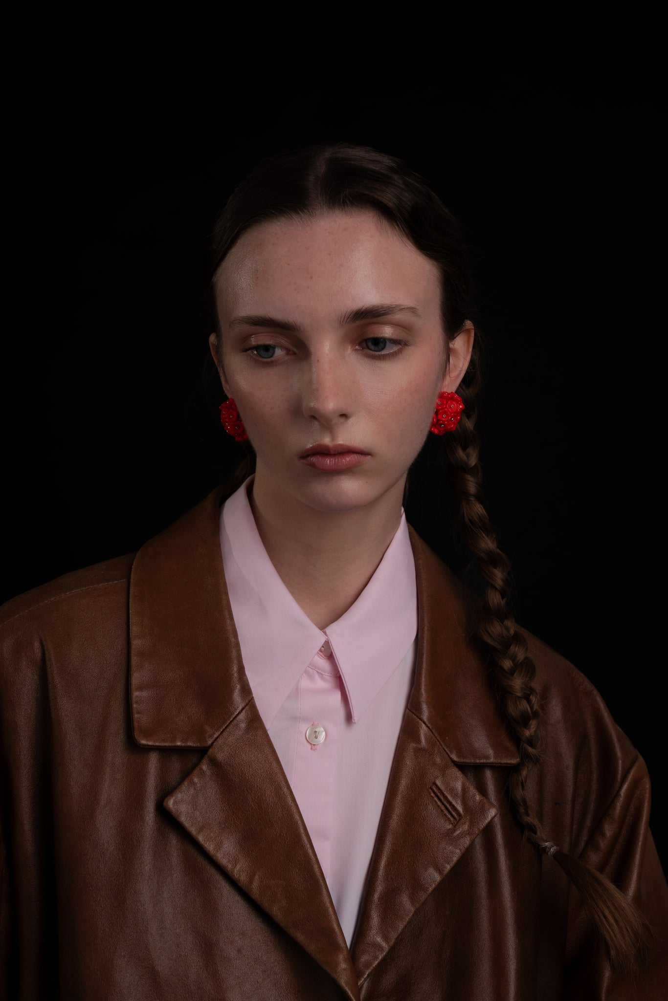 Pendientes en rojo bordados con flores de cristal de checo, de Uchaworld, mostrados en modelo.