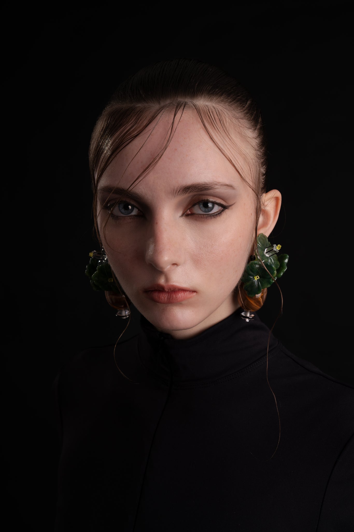 Pendientes florales bordados en verde con colgante, de Uchaworld, mostrados en modelo.