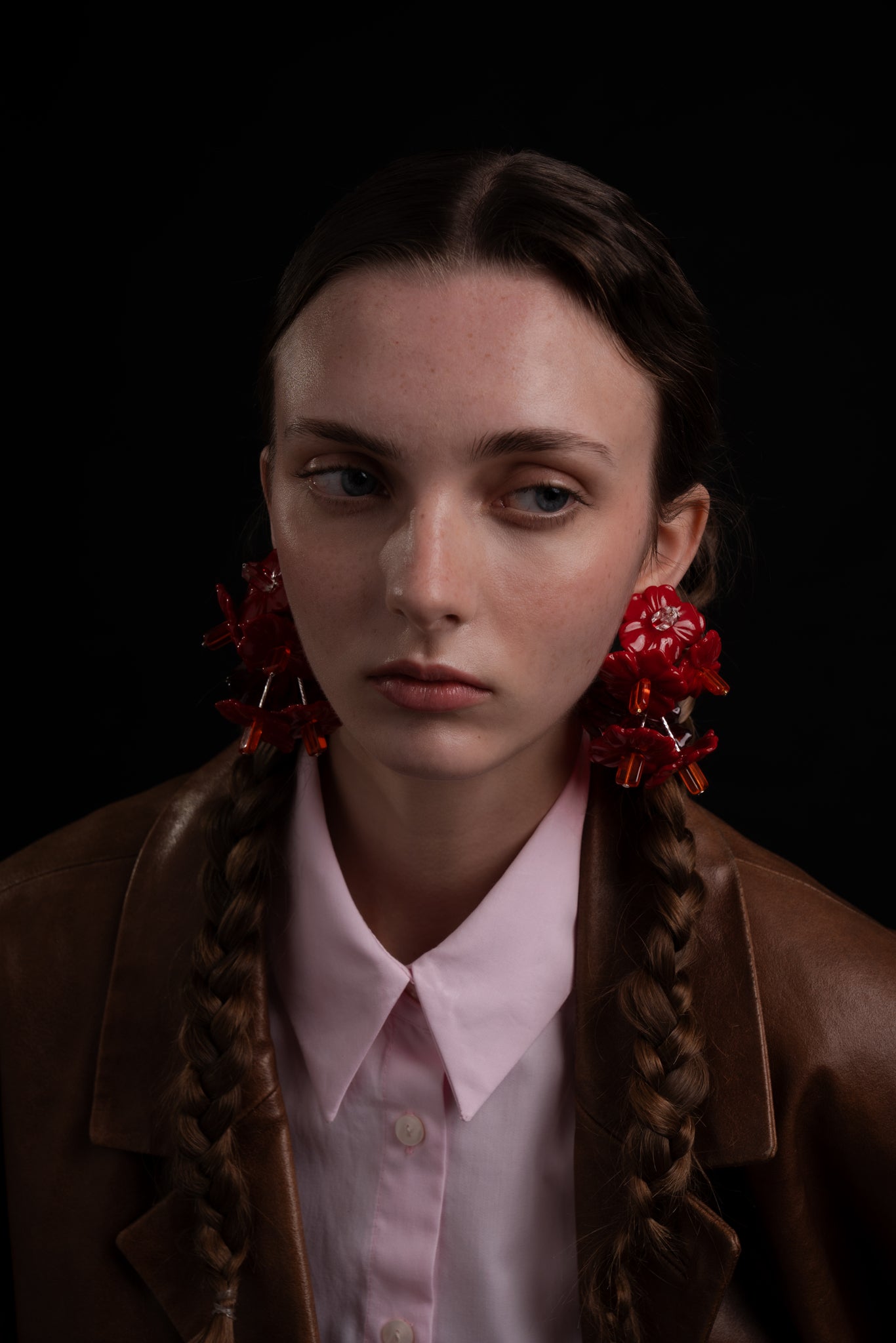 Pendientes bordados en color rojo con diseño floral en modelo, marca Uchaworld.
