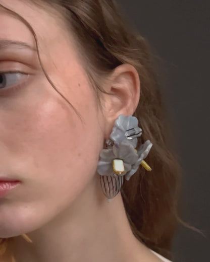 Video de modelo con pendientes bordados en color gris con flores de cristal checo, marca Uchaworld.