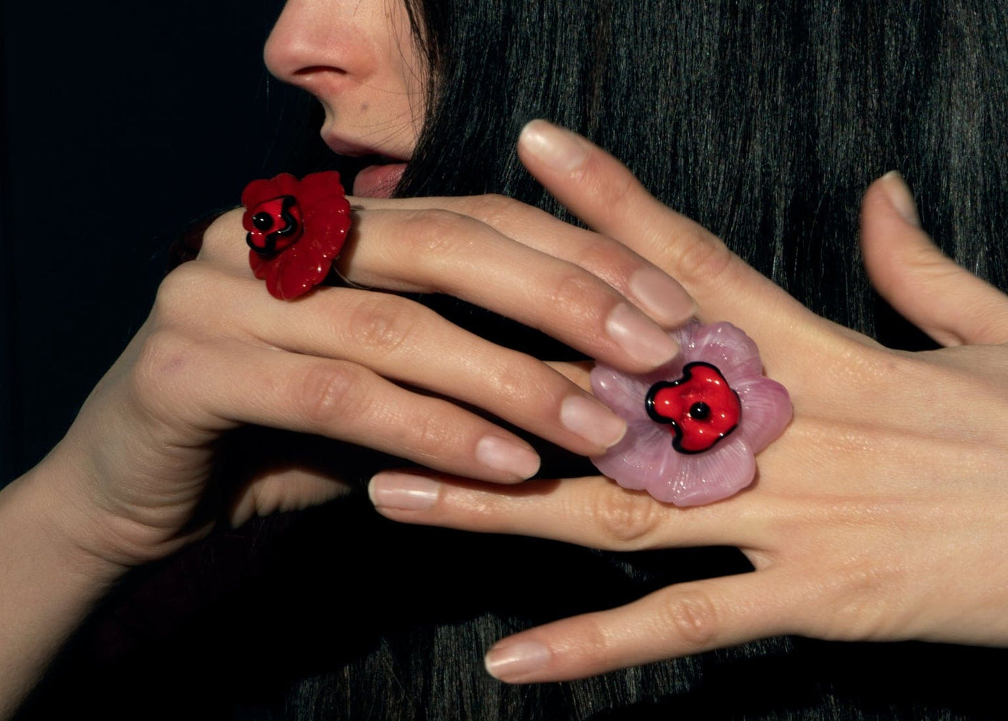 Anillo bordado rosa con diseño floral, flor de vidrio checo y flor de resina vintage, en mano de modelo, marca Uchaworld.
