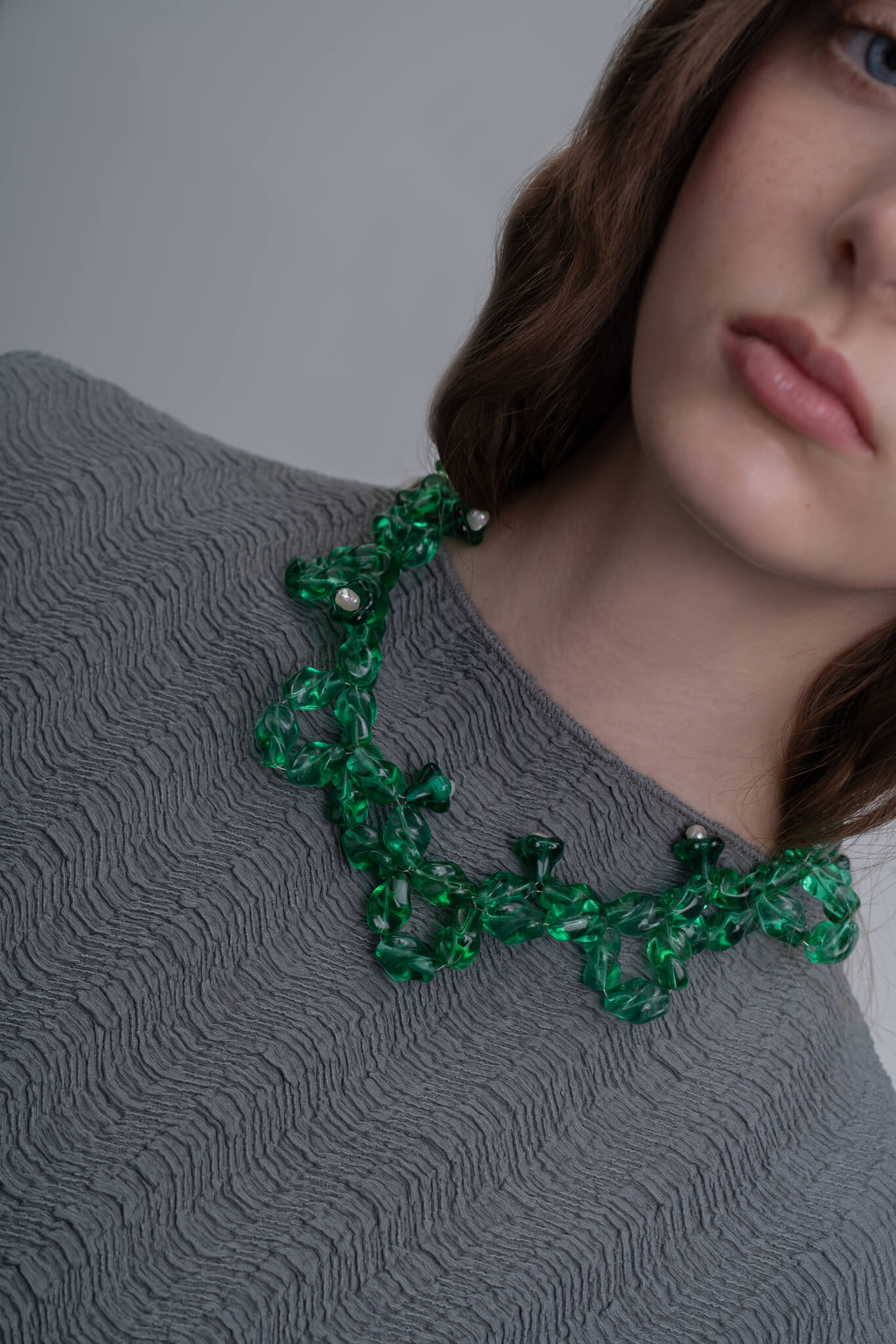 Collar artesanal con diseño retorcido con un elegante tono verde esmeralda, en modelo, marca Uchaworld.