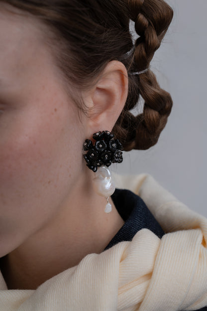 Pendientes bordados en color negro con flores de cristal de checo y perlas de rio natural, en modelo, marca Uchaworld.