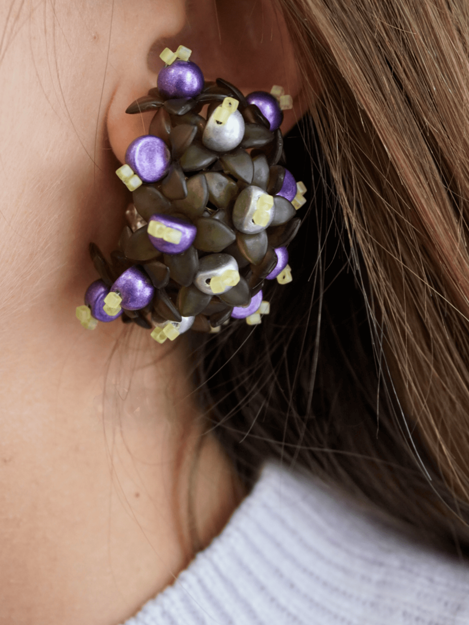 Pendientes bordados con diseño floral, flores acrilicas y cuentas de vidrio de origen japonés, en modelo, marca Uchaworld.